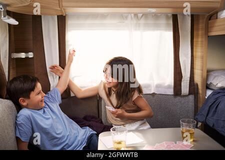 Bambini che giocano a carte in camper Foto Stock