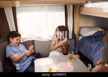 Bambini che giocano a carte in camper Foto Stock