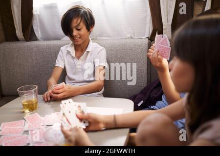 Ragazzo che gioca carte in camper furgone Foto Stock