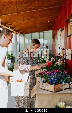 Coppia sorridente che sceglie i fiori in negozio Foto Stock