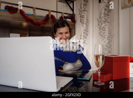 donna e simpatico gatto godetevi festeggiando e sventolando in festa tramite videochiamata conferenza con amici e familiari. Quarantena donna asiatica per la protezione coro Foto Stock