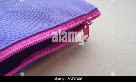 Custodia a matita con zip rosa su sfondo neutro Foto Stock