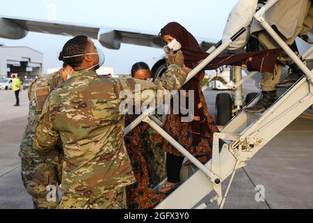 Sigonella, Italia. 26 agosto 2021. I membri del servizio degli Stati Uniti assistono una famiglia afghana evacuata da Kabul all'arrivo alla Stazione aeronavale di Sigonella il 26 agosto 2021 a Sigonella, Italia. NAS Sigonella fornisce alloggio temporaneo per gli evacuati dall'Afghanistan come parte dell'operazione Rifugi Alleati. Credit: Planetpix/Alamy Live News Foto Stock