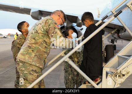 Sigonella, Italia. 26 agosto 2021. I membri del servizio degli Stati Uniti assistono una famiglia afghana evacuata da Kabul all'arrivo alla Stazione aeronavale di Sigonella il 26 agosto 2021 a Sigonella, Italia. NAS Sigonella fornisce alloggio temporaneo per gli evacuati dall'Afghanistan come parte dell'operazione Rifugi Alleati. Credit: Planetpix/Alamy Live News Foto Stock