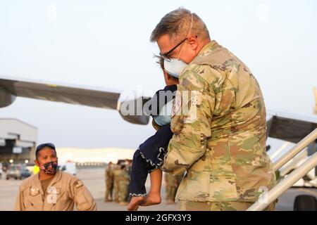 Sigonella, Italia. 26 agosto 2021. I membri del servizio degli Stati Uniti assistono una famiglia afghana evacuata da Kabul all'arrivo alla Stazione aeronavale di Sigonella il 26 agosto 2021 a Sigonella, Italia. NAS Sigonella fornisce alloggio temporaneo per gli evacuati dall'Afghanistan come parte dell'operazione Rifugi Alleati. Credit: Planetpix/Alamy Live News Foto Stock