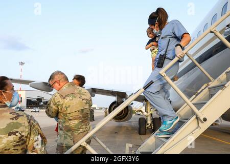 Sigonella, Italia. 26 agosto 2021. I membri del servizio degli Stati Uniti assistono una famiglia afghana evacuata da Kabul all'arrivo alla Stazione aeronavale di Sigonella il 26 agosto 2021 a Sigonella, Italia. NAS Sigonella fornisce alloggio temporaneo per gli evacuati dall'Afghanistan come parte dell'operazione Rifugi Alleati. Credit: Planetpix/Alamy Live News Foto Stock