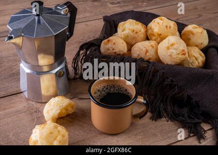 tavolo con deliziosi tipi di pane al formaggio, una tazza di caffè e una macchina per il caffè tradizionale. Foto Stock