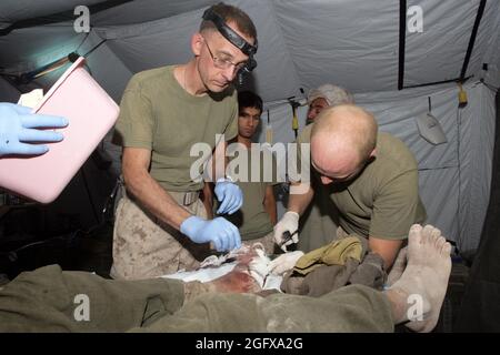 080720-M-1341G-009 PROVINCIA DI FARAH, Afghanistan (20 luglio 2008) U.S. Navy Hospital Corpsman III Classe Christopher Peterson, Right, and Navy CMdR. John Crabill, a sinistra, entrambi assegnati a Golf Company, 2° Battaglione, 7° Regiment Marino, ha tagliato le fasciature da un piede afghano boyÕs alla base operativa di Baqwa in avanti nella provincia di Farah. Basato da Marine Air Ground Combat Center, Twentynine Palms, Calif., 2° Battaglione 7° Reggimento Marino è un'unità di fanteria leggera rinforzata schierata in Afghanistan a sostegno dell'operazione Enduring Freedom. (STATI UNITI Foto del corpo marino di CPL. Jason T. Guiliano/rilasciato) Foto Stock