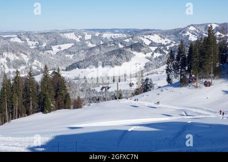 OBERSTAUFEN, GERMANIA - 29 DEC, 2017: Splendida vista sulla stazione invernale di Oberstaufen con una pista da sci in primo piano nelle Alpi bavaresi Foto Stock