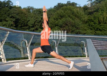 Senti lo stretching nella tua anca. Man do crescent affondo allungare le braccia di sollevamento. Fare yoga o pilates esercizio Foto Stock