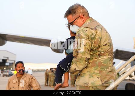 AEROSTAZIONE NAVALE DI SIGONELLA, Italia (agosto 26, 2021) – UN membro del Servizio degli Stati Uniti aiuta un evacuatore dell'Afghanistan a partire da un Clipper dell'Aeronautica militare degli Stati Uniti C-40B alla Stazione aeronavale di Sigonella 26 agosto 2021. NAS Sigonella sta attualmente sostenendo la missione del Dipartimento della Difesa per facilitare la partenza e il trasferimento in sicurezza dei cittadini statunitensi, dei beneficiari di visti speciali per l'immigrazione e delle popolazioni afghane vulnerabili provenienti dall'Afghanistan. La posizione strategica di NAS Sigonella consente a U.S, forze nazionali alleate e partner di schierarsi e rispondere come richiesto per garantire sicurezza e stabilità in Europa, Africa e virgola centrale Foto Stock