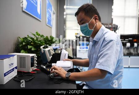 (210827) -- ZHENGZHOU, 27 agosto 2021 (Xinhua) -- un ingegnere prova il sistema di condizionamento di un vestito protettivo medico sviluppato dal gruppo Tuoren nella città di Changyuan di Xinxiang, provincia centrale di Henan della Cina, 26 agosto 2021. Il produttore cinese di consumabili medici Tuoren Group ha sviluppato un tuta protettiva medica a pressione positiva per l'aria condizionata che può fornire aria fredda agli operatori sanitari che li indossano. La temperatura all'interno della tuta è regolabile tra 26 e 29 gradi Celsius. L'indumento non è solo sicuro ed efficace, ma rende anche il lavoro in estate più confortevole. (Xinhua/ Foto Stock