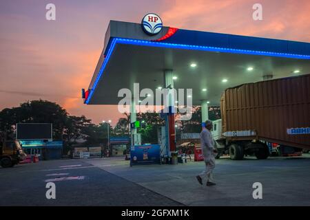 Mumbai, Maharashtra, India - 06 Ott 2018: Un uomo che cammina con una pompa a benzina al mattino presto con il sole che sale Foto Stock