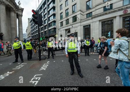 Londra, Regno Unito. 27 agosto 2021. La polizia controlla gli attivisti climatici dalla ribellione di estinzione che protestano fuori dalla Banca d'Inghilterra nella città di Londra. L’evento fa parte della protesta della “rivolta impossibile” di “colpire le cause alla radice della crisi climatica ed ecologica” e rimane in corso per due settimane fino a quando il governo non accetta di fermare tutti i nuovi investimenti di combustibili fossili. Credit: Stephen Chung / Alamy Live News Foto Stock