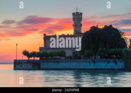 Un tramonto a Schloss Montfort. Le mura del castello di Montfort, un punto di riferimento di Langenargen con una posizione meravigliosa e unica praticamente nel lago C. Foto Stock