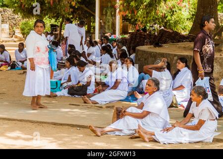 KANDY, SRI LANKA - 19 LUGLIO 2016: Riposo dei pellegrini buddisti vestiti di bianco durante le vacanze di Poya (Luna piena) a Kandy, Sri Lanka Foto Stock