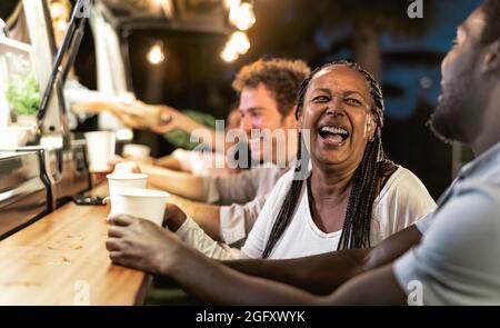 Felice gente multirazziale che acquista pasto dal mercato dei camion del cibo di strada - affari moderni e concetto di take away Foto Stock