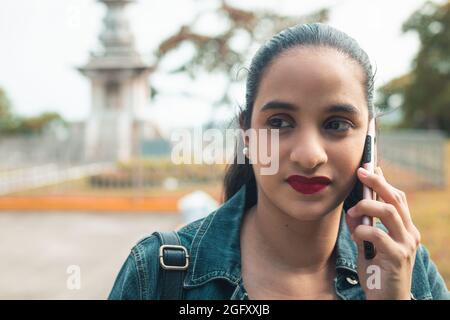 Giovane latino femmina che parla al telefono Foto Stock