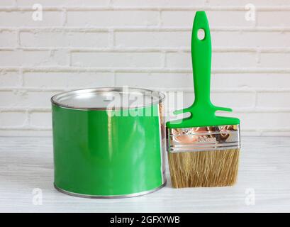 pennello con vernice verde su sfondo chiaro. concetto di ristrutturazione Foto Stock