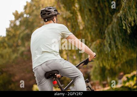 Bicyclist caucasico in copricapo protettivo ciclismo all'aperto Foto Stock