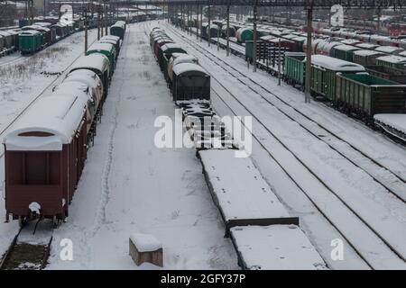 Le auto e le piattaforme per il trasporto sono coperte di neve. Una vista della stazione ferroviaria dall'alto in inverno. Il concetto di trasporto ferroviario. Krasnoda Foto Stock