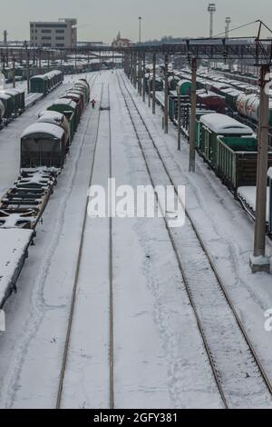 Stazione ferroviaria in inverno. Le auto da trasporto sono coperte di neve. Il concetto di trasporto ferroviario. Krasnodar, Russia, 18 febbraio 2021 Foto Stock