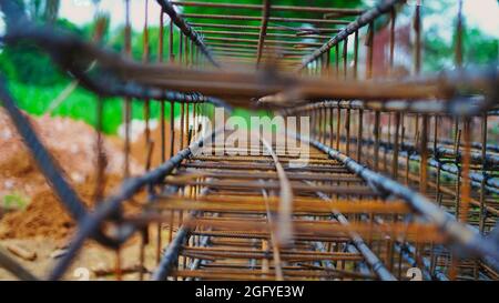 L'edificio in costruzione attende il travaso di solette in calcestruzzo. Cablaggio in metallo arrugginito è posato sul terreno della casa in costruzione. Foto Stock