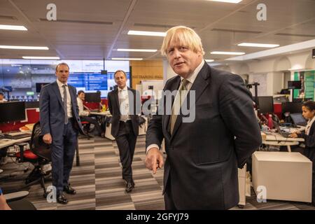 Il primo Ministro Boris Johnson e il Segretario agli Esteri Dominic Raab, con il Direttore Generale Tom Drew, MENA, Afghanistan e Pakistan, visitano il Centro di crisi dell'Ufficio per gli Esteri, il Commonwealth e lo sviluppo di Whitehall, Londra, per vedere come stanno sostenendo e monitorando le evacuazioni in corso in Afghanistan. Data foto: Venerdì 27 agosto 2021. Foto Stock