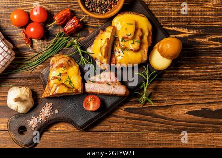 Truppa di maiale marinata in salsa di senape con pancetta e formaggio. Carne alla griglia con formaggio. Porzioni di carne sul tavolo. Foto Stock