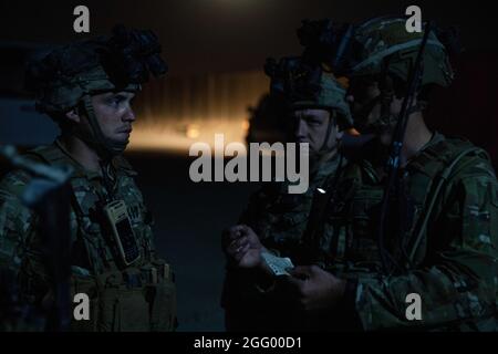 I paracadutisti assegnati alla prima squadra di combattimento Brigade, 82a divisione Airborne ricevono un breve cambio di turno prima di assumere il controllo di un checkpoint all'aeroporto internazionale Hamid Karzai di Kabul, Afghanistan, 25 agosto 2021. Il 82° Abn. Div. Continua a contribuire a facilitare l'evacuazione sicura dei cittadini statunitensi, dei richiedenti di visti speciali per immigrati e di altri afghani a rischio fuori dall'Afghanistan nel modo più rapido e sicuro possibile. (STATI UNITI Foto di cortesia dell'esercito) Foto Stock