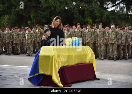 Lviv, Ucraina. 27 ago 2021. (NOTA DEI REDATTORI : immagine raffigura la morte)moglie e figlia si trovano vicino alla bara di un soldato morto sul territorio della ottantesima brigata d'assalto separata. L'addio al soldato caduto Dmytro Hudzik ebbe luogo sulla piazza della ottantesima brigata d'assalto separata. Credit: SOPA Images Limited/Alamy Live News Foto Stock