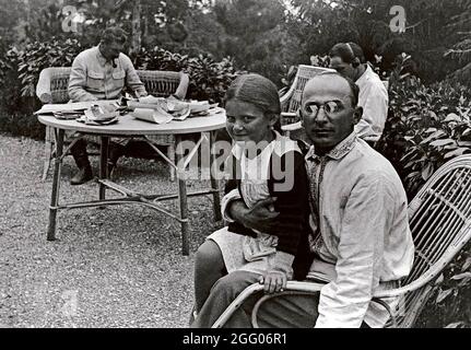 Il capo della NKVD Lavrenti Beria con la figlia di Stain Svetlana sedette in grembo. Stalin è seduto a lavorare a un tavolo in background Foto Stock