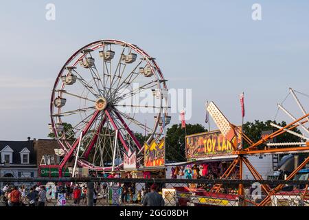 St. Thomas, Ontario, Canada - Luglio 23 2021: Persone che partecipano al Carnevale Estivo di St. Thomas. Ruota panoramica con il simbolo del gruppo Conklin. Foto Stock