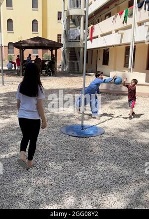 Sigonella, Italia. 24 agosto 2021. Gli evacuati afghani giocano il tetherball alla Stazione aeronavale di Sigonella il 24 agosto 2021 a Sigonella, Italia. NAS Sigonella fornisce alloggio temporaneo per gli evacuati dall'Afghanistan come parte dell'operazione Rifugi Alleati. Credit: Planetpix/Alamy Live News Foto Stock