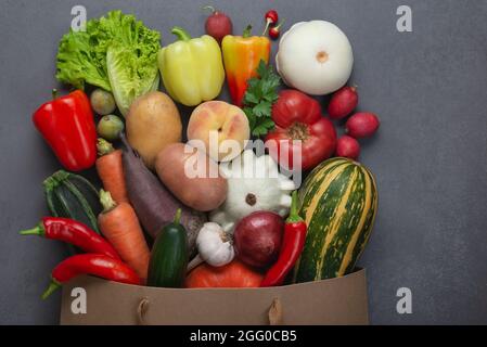 Cibo vegetariano vegano sano in sacchetto di carta verdure e frutta sul grigio Foto Stock