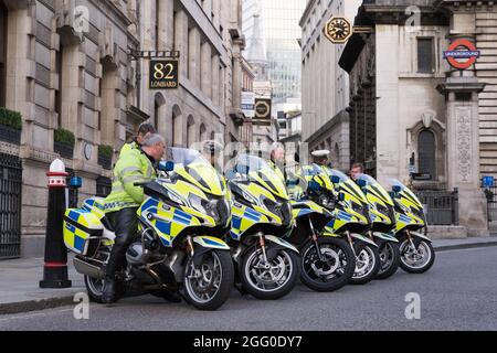 Londra, Regno Unito. 27 agosto 2021. Extinction Rebellion (XR) e i manifestanti di ribellione animale tour il quartiere finanziario di Londra, Square Mile, nella notte, occupano la casa di casa di giunzione della regina Victoria Street e Cannon Street, tutta la via Bank of England, Contro il cambiamento climatico globale. Salire sulla cima di strutture di legno erette in mezzo alla strada. Per protestare contro gli investimenti nei combustibili fossili. Polizia moto standby per legge e ordine. Credit: Xiu Bao/Alamy Live News Foto Stock