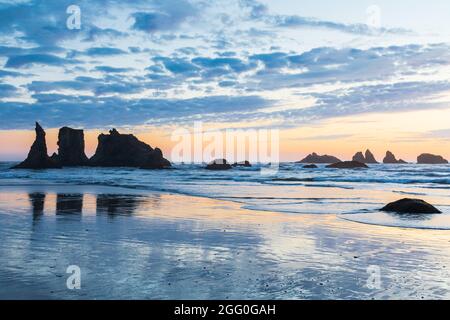 Bandon, Oregon, Stati Uniti. Il mare si impila sulla costa dell'Oregon al tramonto. Foto Stock