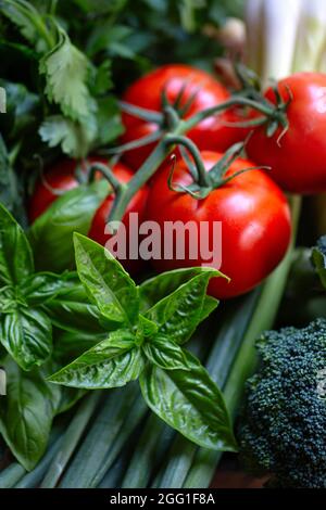 Pomodori, broccoli, cipolle verdi e basilico da vicino Foto Stock