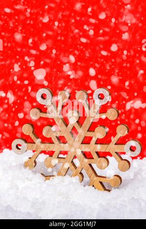 Neve su sfondo rosso, nevicate o nevicate. Grande fiocco di neve in legno. Concetto di Natale. Tema Capodanno, foto panoramica per un Foto Stock