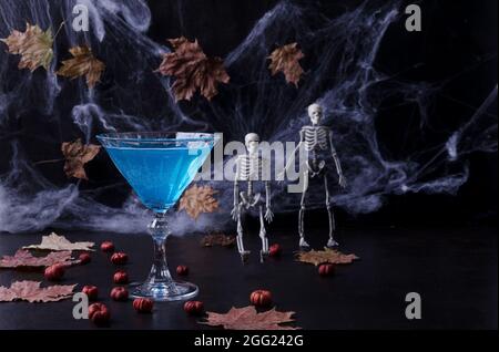 Cocktail di Halloween. Drink di Natale. Festa di Halloween. Zucche, ragnatele, scheletri su sfondo scuro in chiave scura. Messa a fuoco selettiva Foto Stock