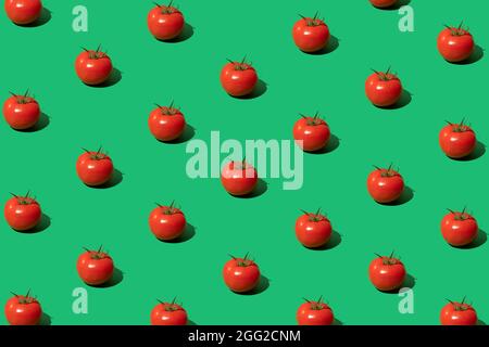 Concetto minimal fatto di pomodoro modello su sfondo verde. Pomodori rossi composizione pop art. Verdure alla moda. Disposizione piatta. Foto Stock