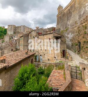 Vista pittoresca di Sorano con scalinata, vicolo, sottopasso e piante nel borgo medievale toscano Foto Stock