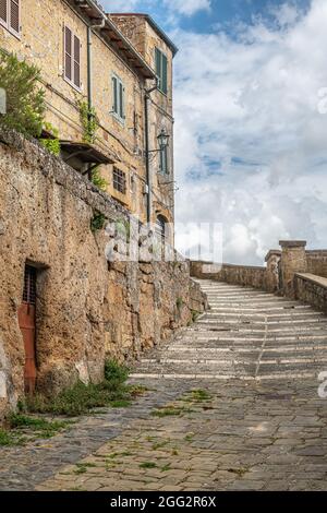 Vista pittoresca di Sorano con scalinata, vicolo, sottopasso e piante nel borgo medievale toscano Foto Stock