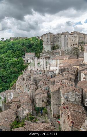 Vista pittoresca di Sorano con scalinata, vicolo, sottopasso e piante nel borgo medievale toscano Foto Stock