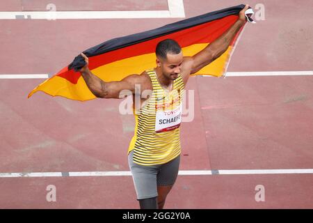 Tokio, Giappone. 28 agosto 2021. Paralimpiadi: Atletica, salto lungo, uomini, finale, allo Stadio Olimpico. Due dei vincitori della medaglia si riuniscono prima della cerimonia di premiazione. Il medaglia d'argento Leon Schäfer, tedesco, tiene in mano la sua bandiera nazionale. Credit: Karl-Josef Hildenbrand/dpa/Alamy Live News Foto Stock