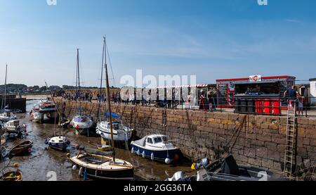 North Berwick, East Lothian, Scozia, Regno Unito, 28 agosto 2021. UK Meteo: La città balneare è piena di persone che si godono il mare e i vari sport acquatici in offerta in un fine settimana di vacanza soleggiato e caldo banca. Nella foto: Una lunga coda si forma per il popolare Lobster Shack decollo nel porto Foto Stock
