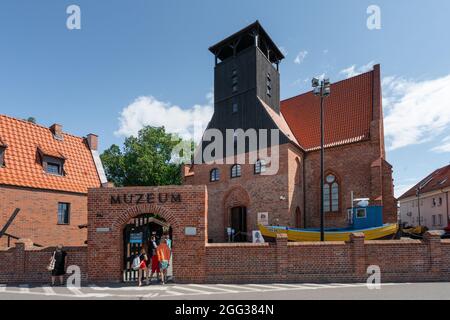 Hel, Polonia - 08.01.2021: Persone che entrano in mattoni rossi edificio del Museo della pesca a Hel, un dipartimento del Museo Nazionale del Mare Foto Stock