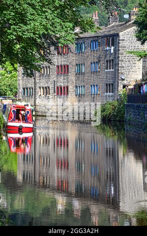 Narrowboat e Weavers Cottages riflette nel canale di Rochdale, Hebden Bridge, Calderdale, West Yorkshire Foto Stock