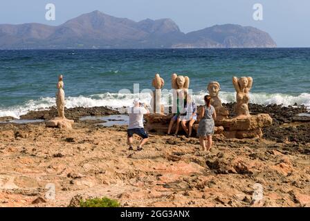 CAN PICAFORT, SPAGNA - LUGLIO 25: I turisti scattano foto di fronte alle sculture di Joan Bennassar in spiaggia il 25 Luglio 2021 a Can Picafort, Spagna. Foto Stock