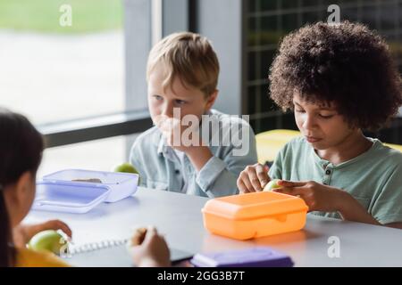 bambini interrazziale che pranzano in un ristorante a scuola Foto Stock